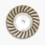 Front view of a 100mm aluminium diamond cup wheel, showing the aggressive segmented rim used for grinding refractory materials.